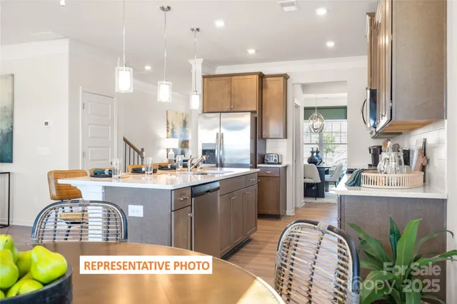 a kitchen with stainless steel appliances granite countertop a sink a stove and a wooden floors