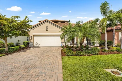 a view of a house with a yard and potted plants