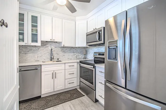 a kitchen with stainless steel appliances granite countertop a refrigerator sink and stove