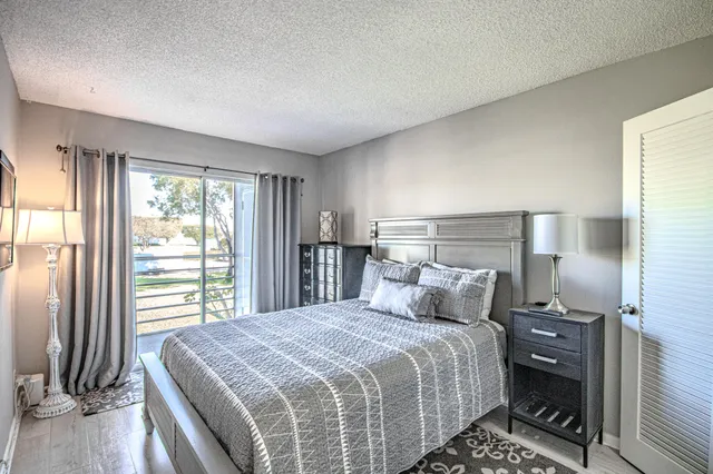 a bedroom with a bed and a lamp on dresser