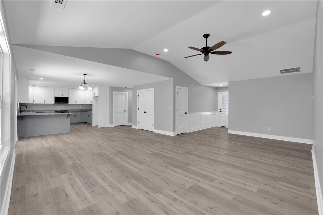 1747 A State Rd S-4-97 Anderson, SC 29621 - Photo 9 of 47 An open-concept living space integrates a modern kitchen and dining area with light wood-style flooring.