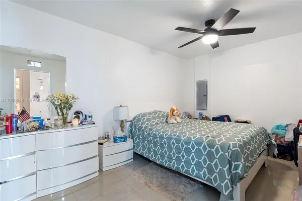 a bedroom with a bed chandelier and a dresser