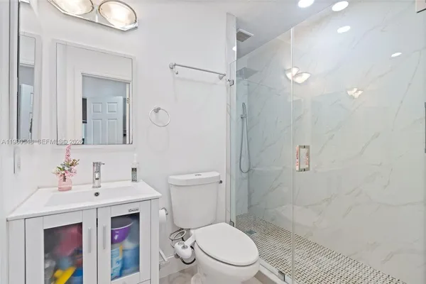 a bathroom with a sink a toilet and shower