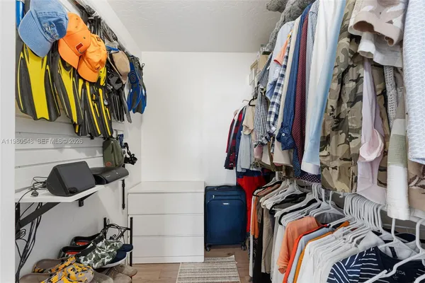 a view of walk in closet with clothes and shoes