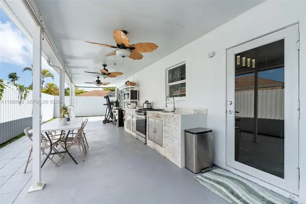 a dining hall with stainless steel appliances kitchen island granite countertop a table and chairs