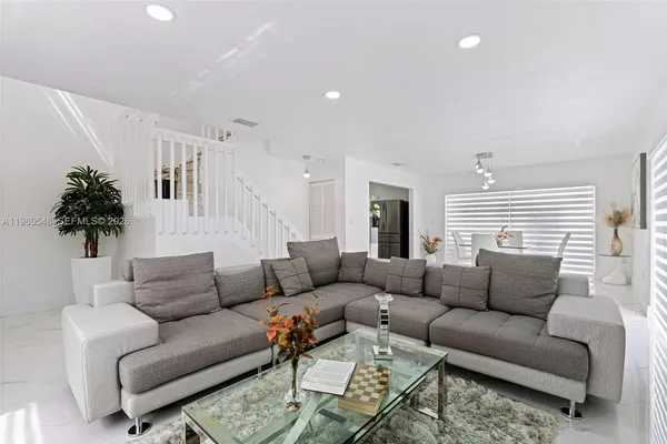 a living room with furniture a couch and a potted plant