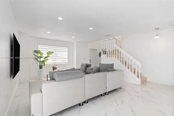 a living room with furniture a chandelier and a flat screen tv