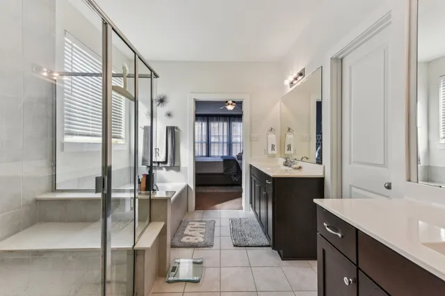 a spacious bathroom with a double vanity sink a mirror and a shower