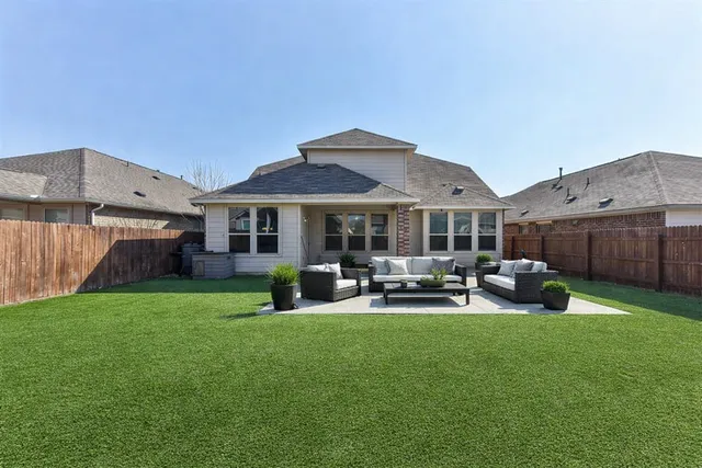 a patio that has couches chairs and a big yard