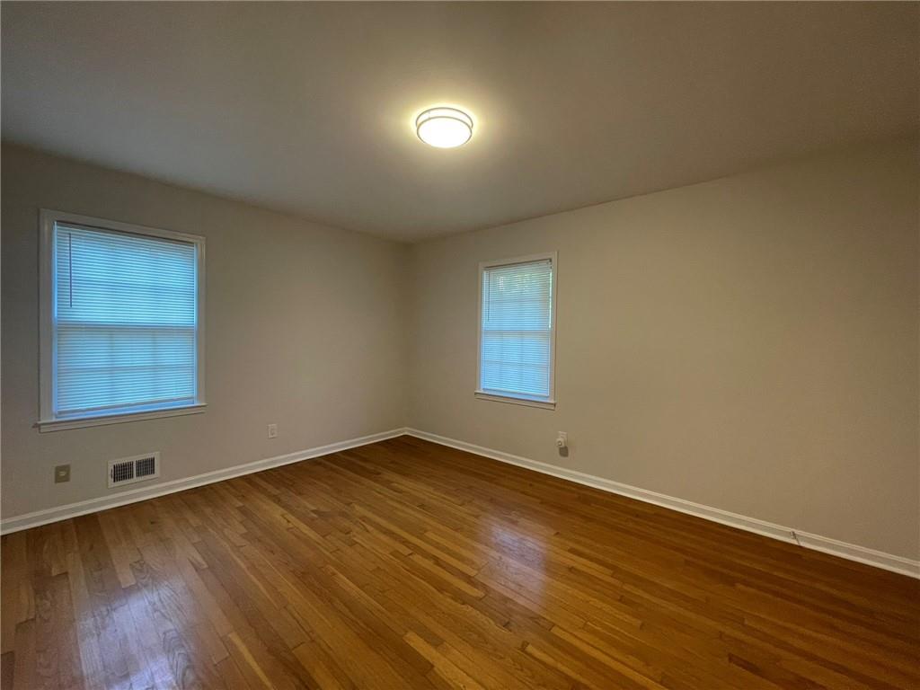 2297 Hylaea Road Tucker, GA 30084 - Photo 7 of 15 a view of an empty room with wooden floor and a window