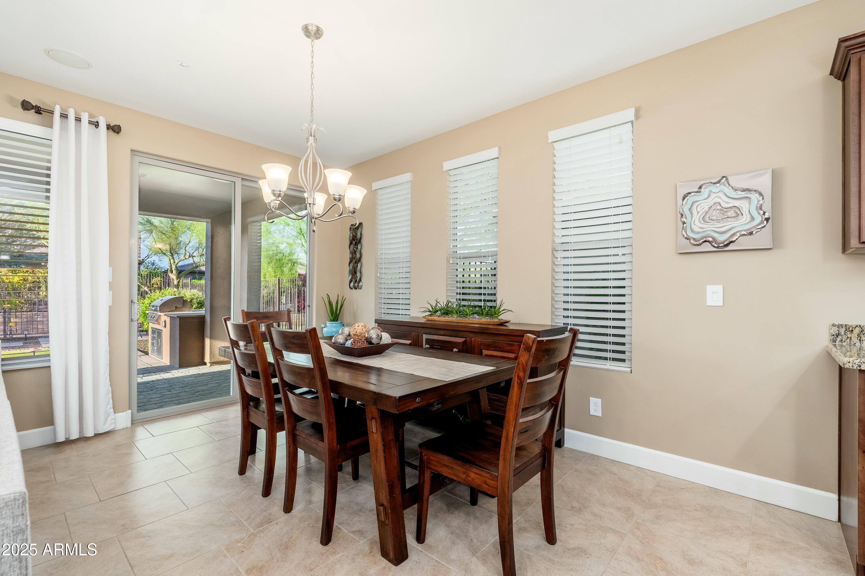17972 East Silver Sage Lane Rio Verde, AZ 85263 - Photo 13 of 80 a dining room with furniture a chandelier and window