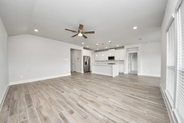 wooden floor in an empty room with a kitchen