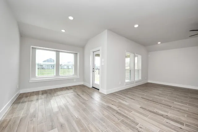 a view of a hallway with wooden floor and white cabinet