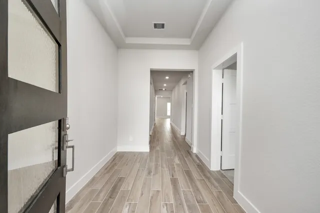 a view of a hallway with wooden floor
