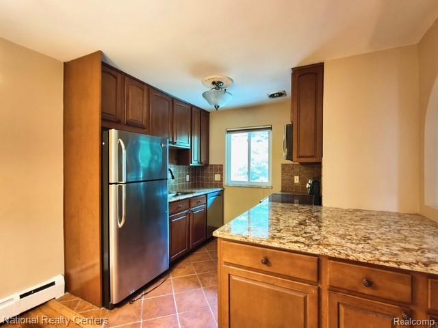 475 South Adams Road, Unit 19 Birmingham, MI 48009 - Photo 11 of 20 Kitchen featuring stainless steel refrigerator, wood cabinetry, granite countertops, and tiled flooring