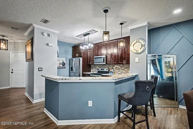 a kitchen with granite countertop stainless steel appliances and wooden cabinets