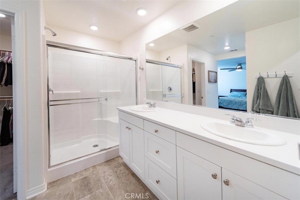 32078 Rambling Court Winchester, CA 92596 - Photo 30 of 48 a bathroom with a shower sink and mirror