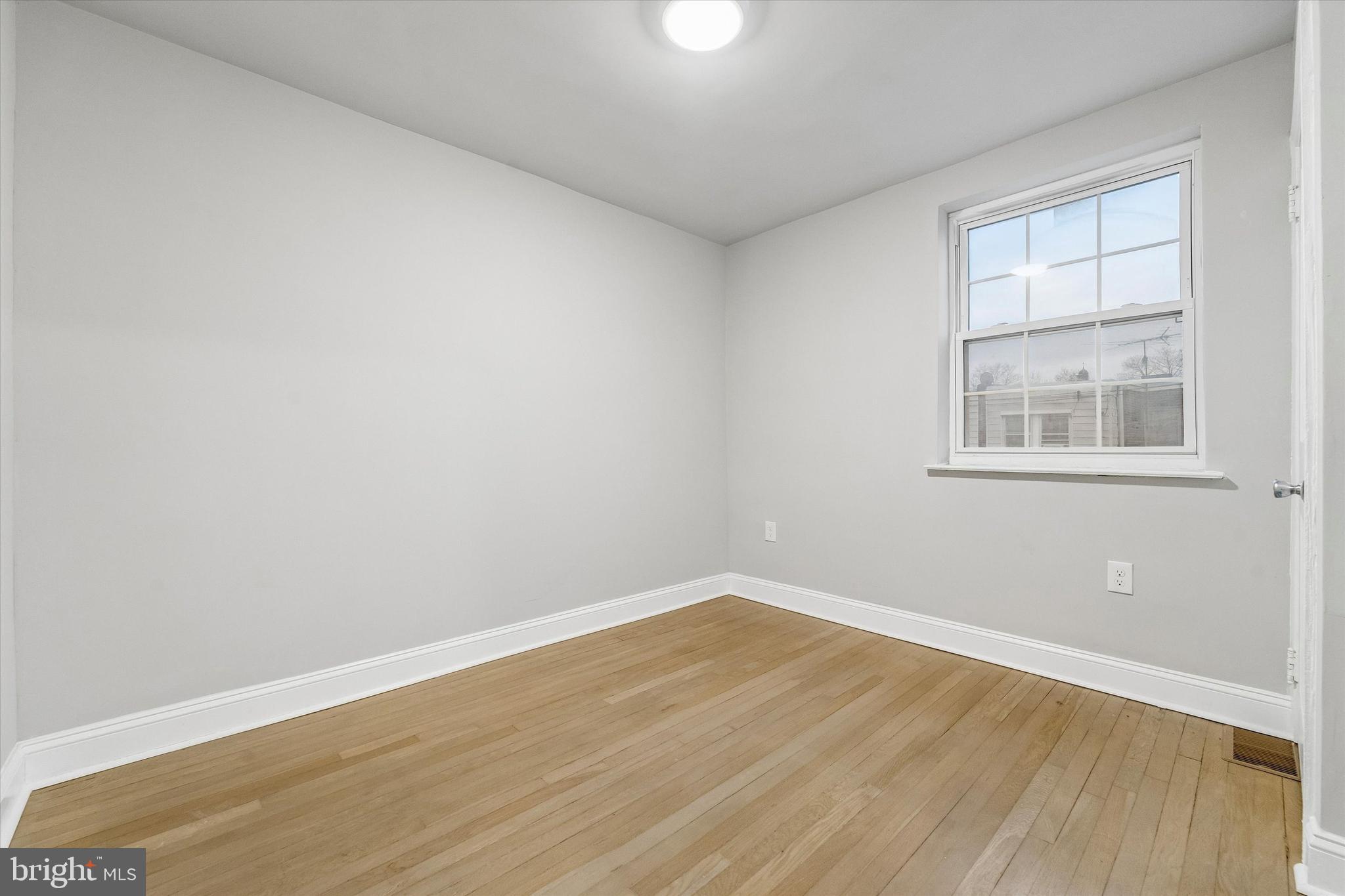 332 Springton Road Upper Darby, PA 19082 - Photo 12 of 15 an empty room with wooden floor and windows