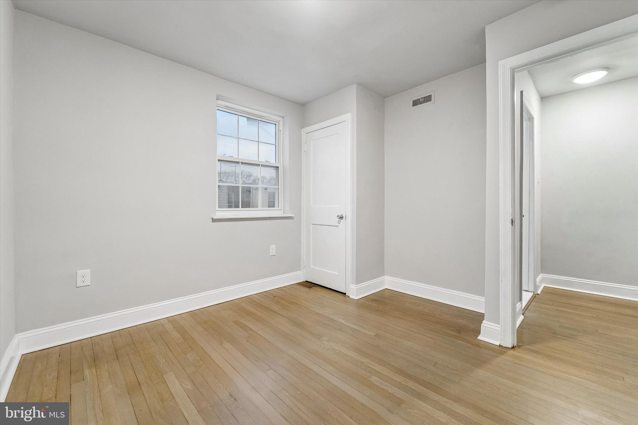 332 Springton Road Upper Darby, PA 19082 - Photo 13 of 15 an empty room with wooden floor and windows