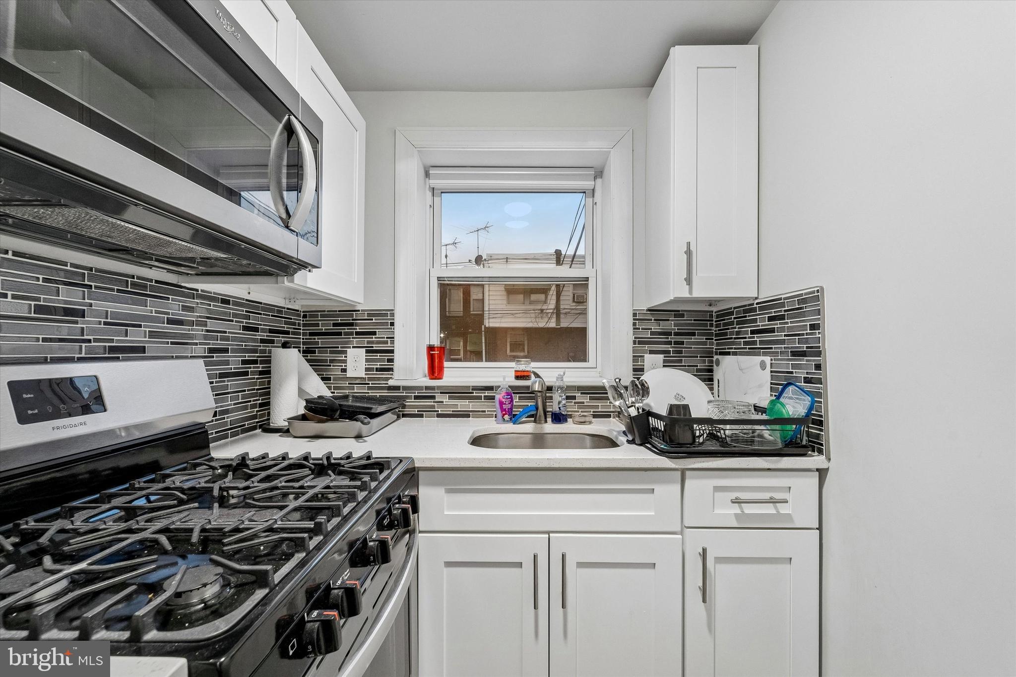332 Springton Road Upper Darby, PA 19082 - Photo 4 of 15 a kitchen with stainless steel appliances a stove a sink and a microwave