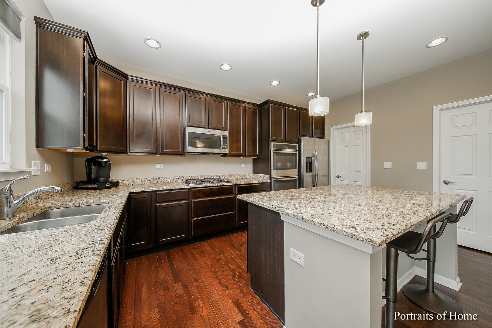 3740 Ryder Court Naperville, IL 60564 - Photo 4 of 25 a kitchen with kitchen island granite countertop a sink a counter top space appliances and cabinets