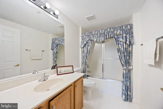 a front view of a building with lot of cars and trees