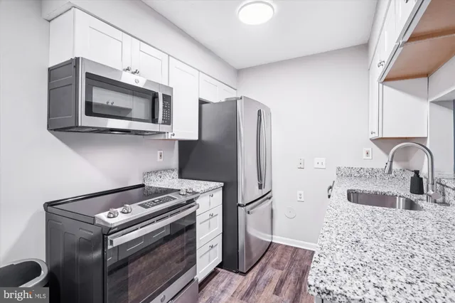 a kitchen with stainless steel appliances granite countertop a stove microwave and refrigerator