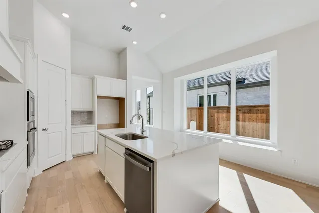 a kitchen that has a sink and a stove top oven