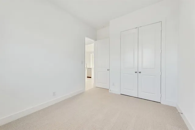 an empty room with a window and a ceiling fan