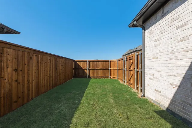 a view of a backyard with wooden fence