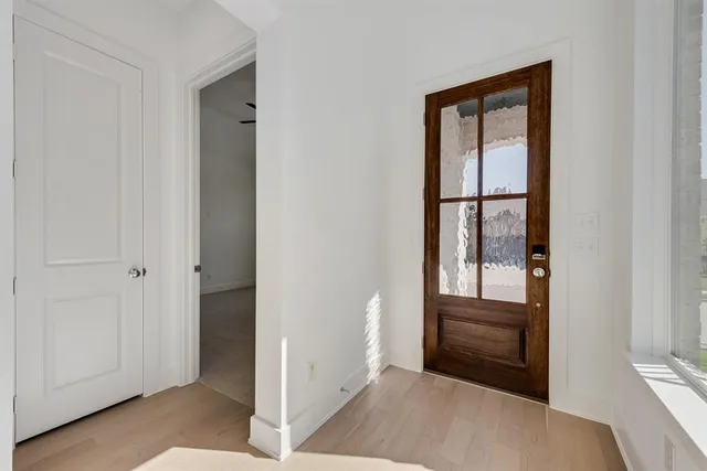 a view of a hallway with wooden floor and entryway