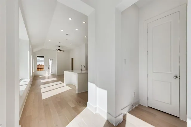 an empty room with chandelier fan and windows
