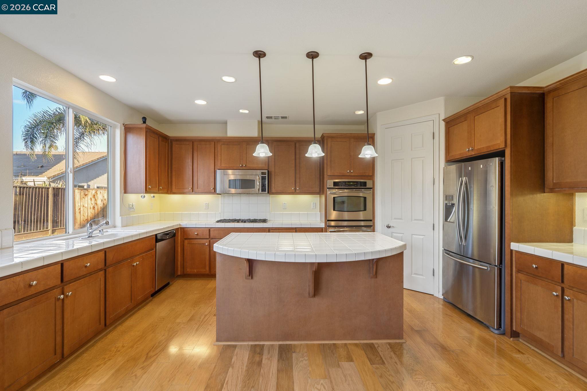 5141 Fern Ridge Circle Discovery Bay, CA 94505 - Photo 11 of 56 a large kitchen with stainless steel appliances kitchen island granite countertop a large island in the center