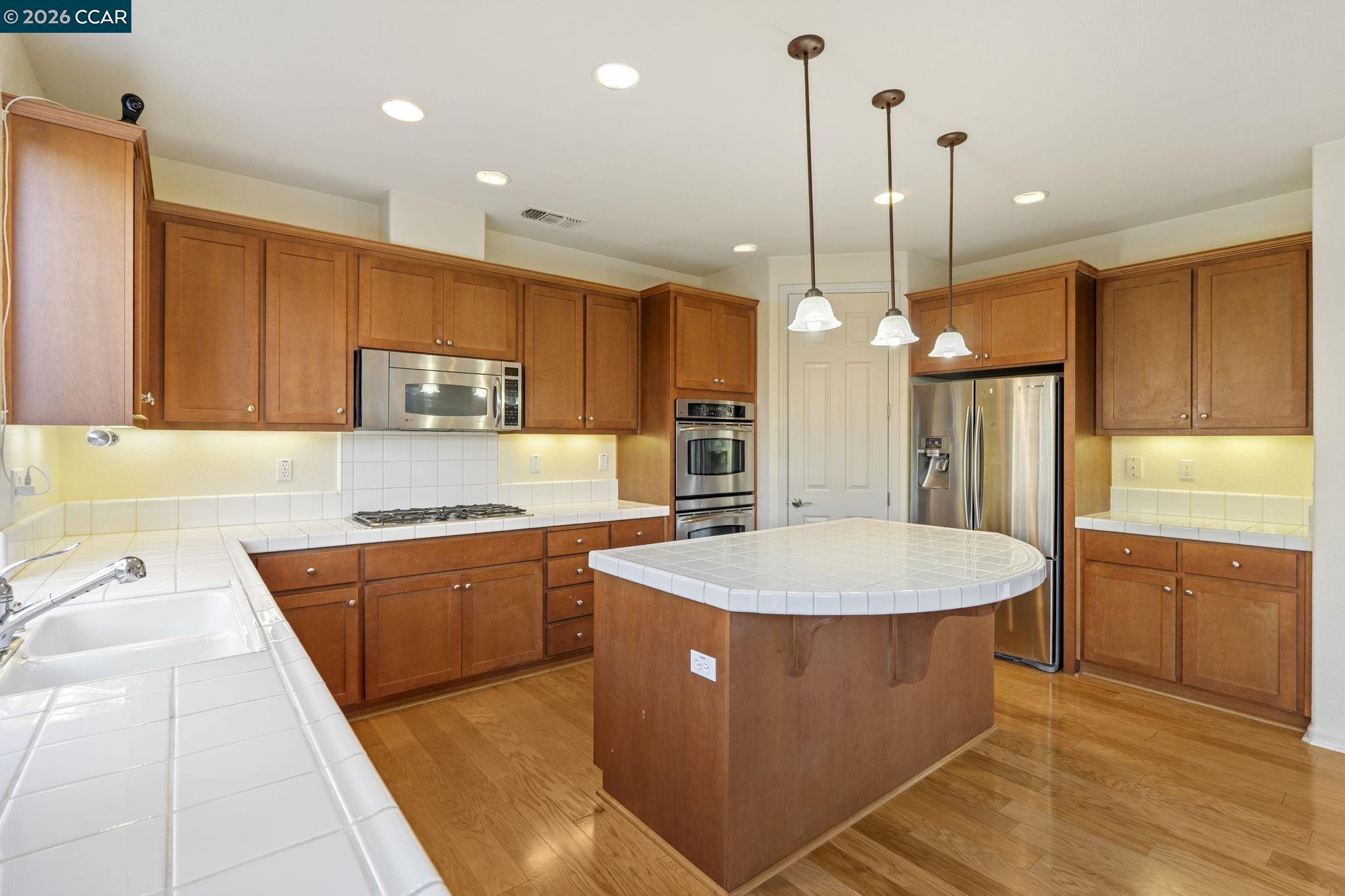 5141 Fern Ridge Circle Discovery Bay, CA 94505 - Photo 12 of 56 a kitchen with stainless steel appliances granite countertop a sink a stove a refrigerator a center island and cabinets