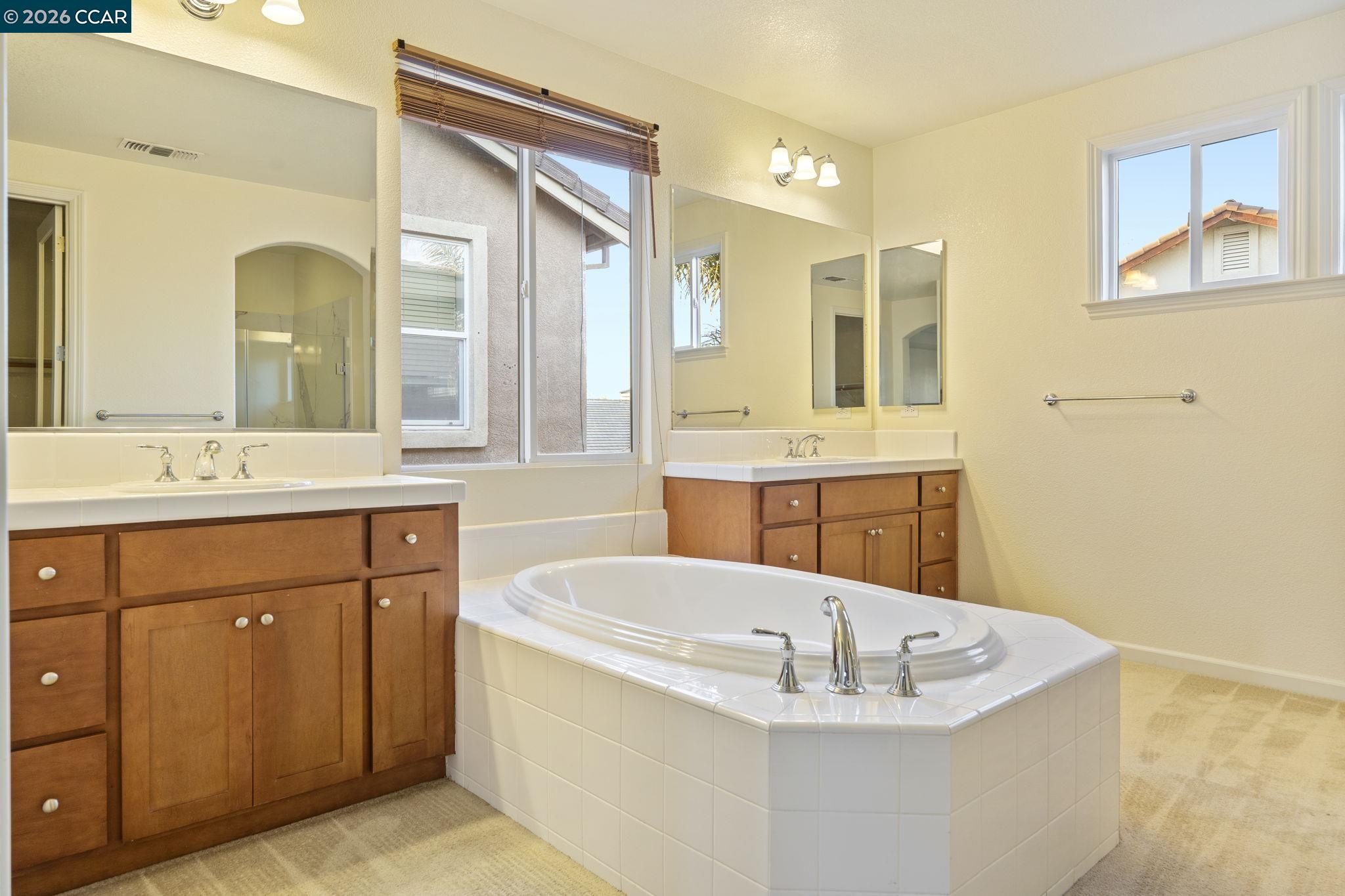 5141 Fern Ridge Circle Discovery Bay, CA 94505 - Photo 42 of 56 a bathroom with a tub a sink double vanity and a mirror