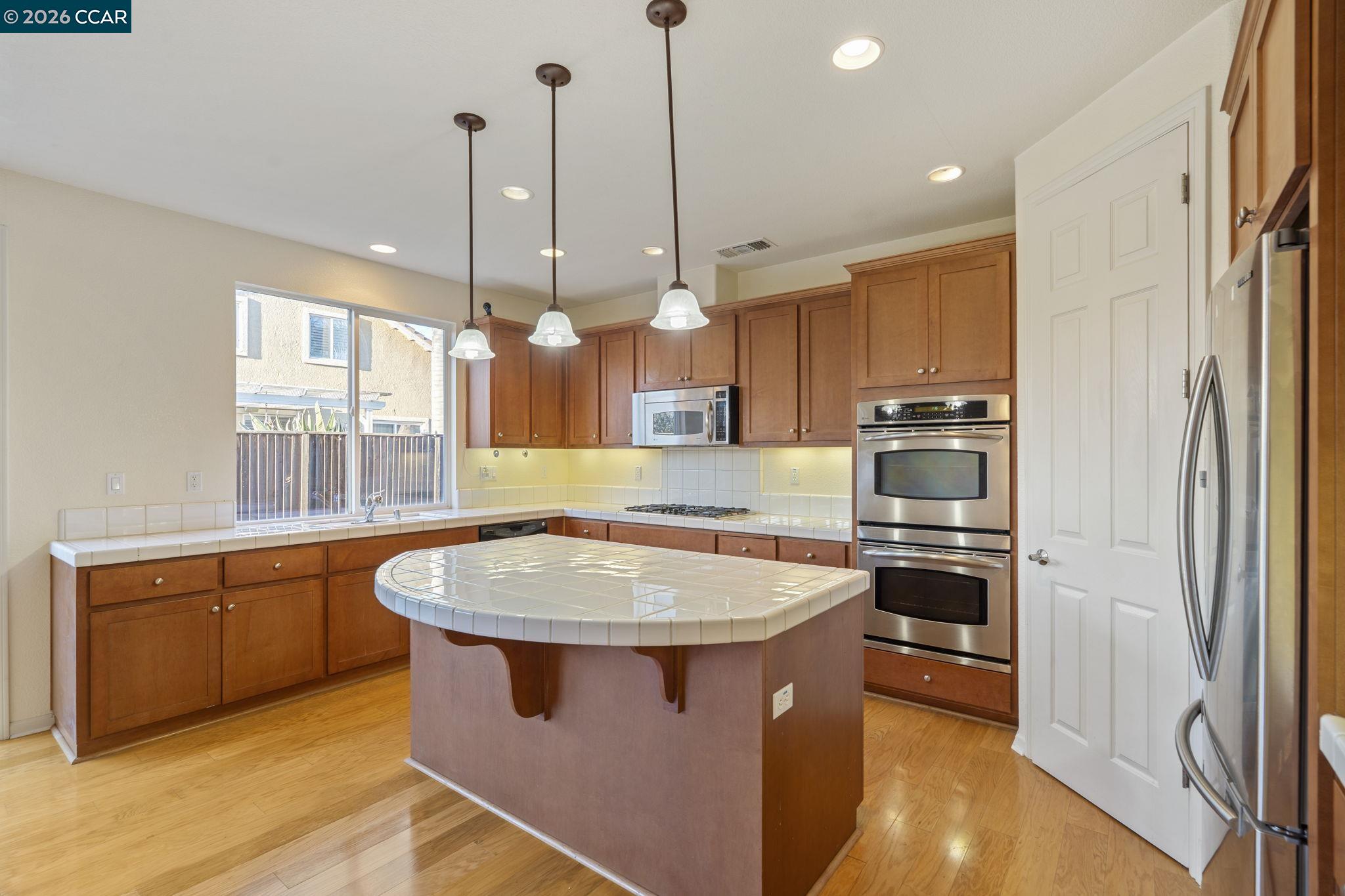 5141 Fern Ridge Circle Discovery Bay, CA 94505 - Photo 10 of 56 a kitchen with stainless steel appliances granite countertop a sink a stove and a wooden floors