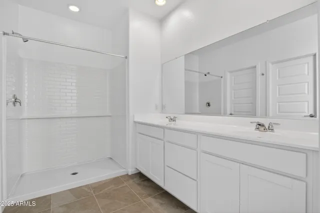 a bathroom with double sink and a shower