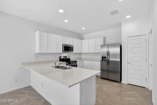 a kitchen that has a sink cabinets counter space and stainless steel appliances