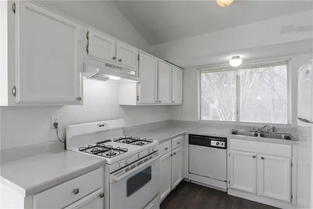 a kitchen with cabinets appliances and a window