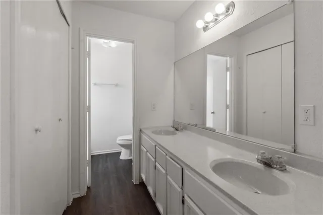 a bathroom with a granite countertop sink a toilet and a mirror