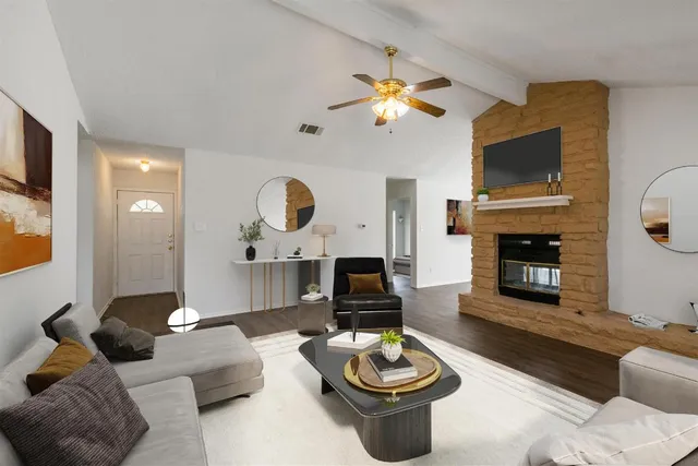 a living room with furniture a flat screen tv and a fireplace