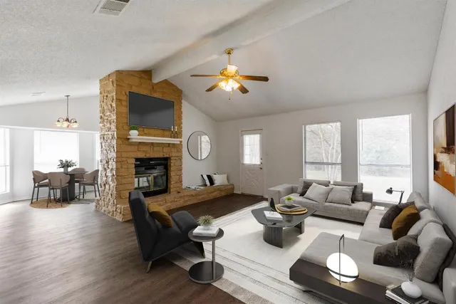 a living room with furniture fireplace and a large window