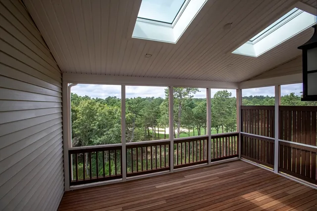 a view of a balcony with floor to ceiling windows with wooden floor