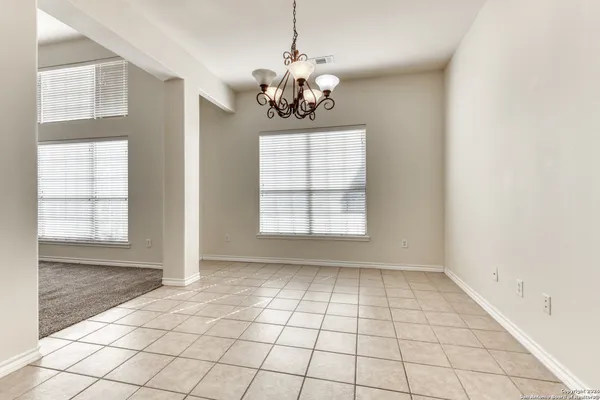 an empty room with windows and chandelier