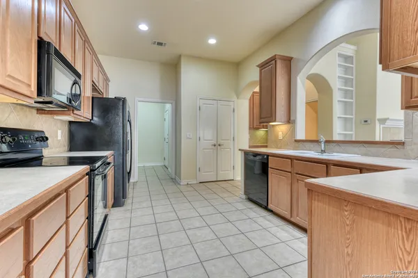 a kitchen with stainless steel appliances granite countertop a refrigerator a sink and a stove