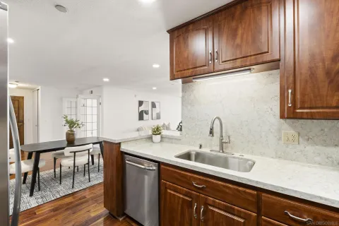 a kitchen with stainless steel appliances granite countertop a sink a stove and wooden cabinets