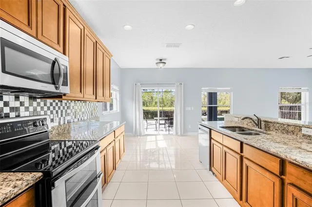 a kitchen with stainless steel appliances granite countertop a stove a sink and a microwave