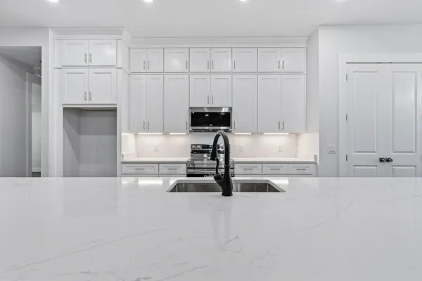 a view of kitchen with kitchen island stainless steel appliances sink and wooden floor