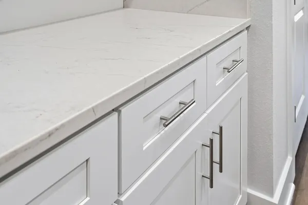 a open kitchen with white cabinets and wooden floor