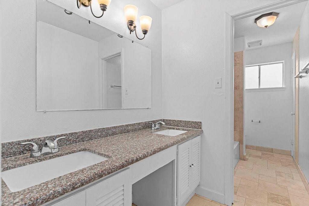 8918 Grape Street Houston, TX 77036 - Photo 36 of 40 a bathroom with a granite countertop sink and a mirror